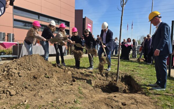 Leerlingen, rector Mascha Schnitzler, wethouder Nick Hubers en Egbert-Jan Rots, directeur van Rots Bouw, planten samen de boom